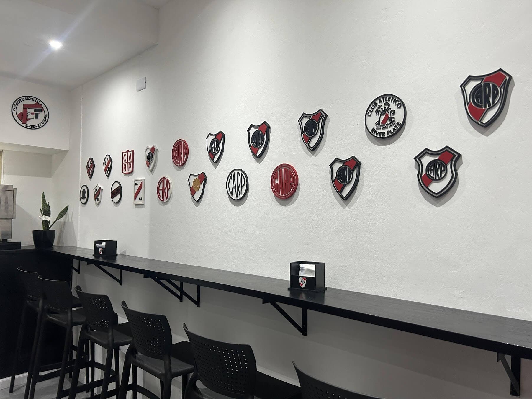 Pared con escudos históricos de River Plate en la sede